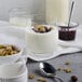 A white bowl of Pequea Valley Farm plain yogurt with granola and jam.
