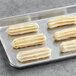 White Toque caramel filled churros on a gray tray.