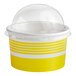 A yellow and white paper frozen yogurt cup with a clear dome lid.