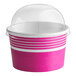 A pink and white paper frozen yogurt cup with a clear dome lid.