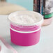 A close-up of a pink Choice paper frozen yogurt cup with a flat lid.