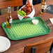 A rectangular Cambro tray with a football field design filled with food and beer on a table.