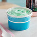 A close-up of a blue paper frozen yogurt container with a flat lid.