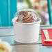 A white Choice paper cup of chocolate ice cream with a clear plastic lid.
