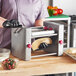 A person in black gloves using the Estella Manual Turnover Machine to make a pastry.