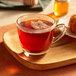 A wooden tray with a glass cup of Bigelow English Breakfast Tea.