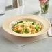 A tan Acopa Foundations melamine pasta bowl filled with pasta, broccoli, and cheese.