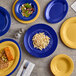 A blue and yellow Acopa Foundations melamine platter with a variety of food on it.
