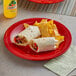 An Acopa Foundations red melamine plate with a burrito and chips on it.