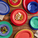 A green Acopa Foundations wide rim melamine platter with food on a table.