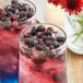 A close-up of two glasses of blue and red drinks with Mixologist's Garden freeze-dried blueberries.
