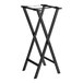 A black wood Lancaster Table & Seating folding tray stand on a table.