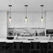 A black and white kitchen with a marble countertop and a Globe Glam Matte Black pendant light.