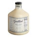 A bottle of Guittard Sweet Ground White Satin Chocolate Flavoring Sauce with white liquid inside.