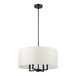 A black pole with a white shade on a Globe Matte Black Chandelier.