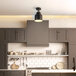 A kitchen with a Globe matte black flush mount light above a white counter top with a black handle.