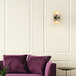 A purple couch in a room with a Globe Glam Matte Brass wall sconce.