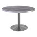 A Holland Bar Stool round table with a metal base and grey top.