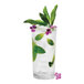 A Tossware plastic highball glass with ice water, mint leaves, and flowers.