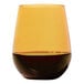A Tossware amber plastic stemless wine glass with brown liquid in it.