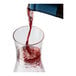 A Tossware plastic decanter filled with red wine on a table.