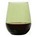 A Tossware Moss green plastic stemless wine glass filled with red wine.