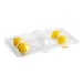 A clear plastic container with yellow lemon cake pops.