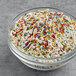 A bowl of Supernatural Rainbow Pop! sprinkle mix on a table.