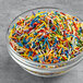 A bowl of Supernatural Rainbow Crunchies all-natural sprinkles in various colors.