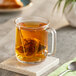 A glass mug of Dona Amber Assam Black Tea on a table.