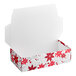A white candy box with red and white poinsettias on it with the lid open.