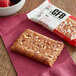 A GFB Cranberry Toasted Almond bar with berries and nuts.