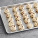 Preformed Otis Spunkmeyer red, white, and blue cookie dough on a gray baking sheet.