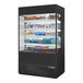 A True refrigerated air curtain merchandiser with glass sides filled with food and drinks.