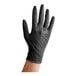 A hand wearing a black Midwest Rake disposable nitrile glove.