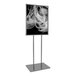 A 22" x 28" chrome bulletin sign holder with a black and white photo of a woman's face on it.