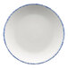 A white porcelain coupe plate with a blue sponged rim.