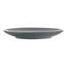 A dark grey International Tableware stoneware coupe plate with a rim.