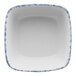 A white square porcelain bowl with a blue sponged border.