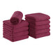 A stack of burgundy Monarch Brands Coral Fleece hand towels.