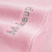 A pink Monarch Brands wash cloth with the word "makeup" in coral.