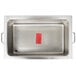 A stainless steel APW Wyott countertop food warmer with a red label on the pan in a school kitchen.