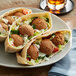 A plate of Kronos falafel balls on a table.