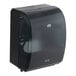 A black Tork electronic hand towel dispenser with a clear plastic cover.