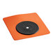 An orange square Oatey wall flashing with a black disc on it.