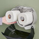 A hand holding Tork standard 2-ply toilet paper rolls.