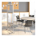 A Flash Furniture clear acrylic room divider with lockable casters separating a table and chairs.
