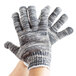 A person's hand wearing a small Cordova work glove with grey and white stripes.