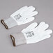 A pair of white gloves with white polyurethane coating on the palms and brown trim.