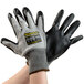 A pair of Cordova Monarch gray and black gloves with black HCT nitrile palms being worn on a pair of hands.